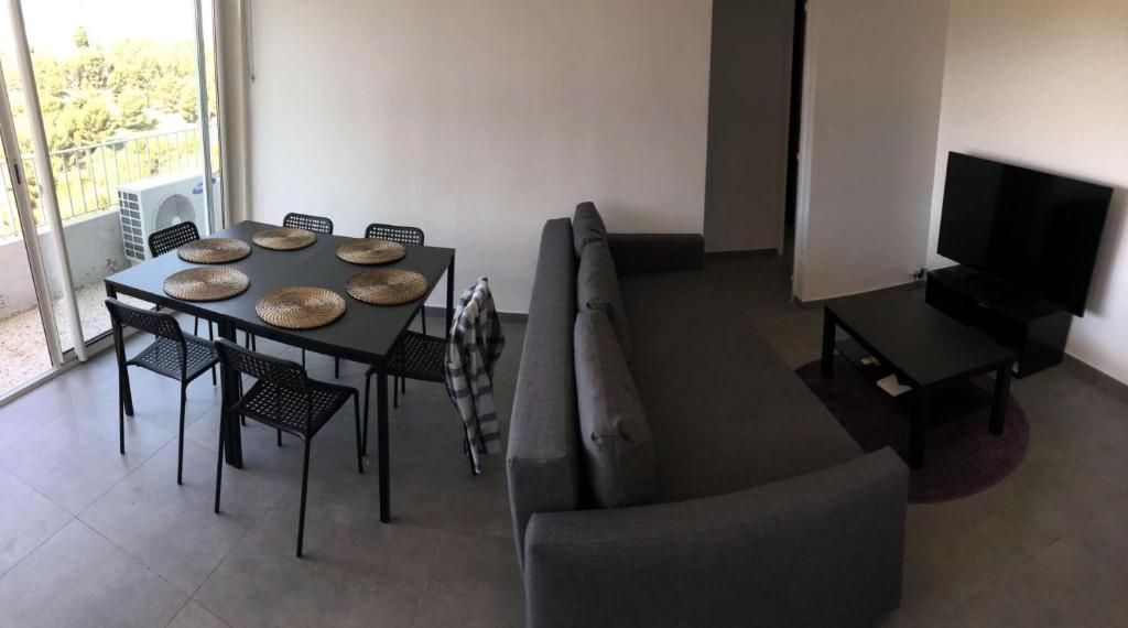 a living room with a table and a couch at Résidence Rouviere - 5 Pièces pour 8 Personnes 684 in Marseille