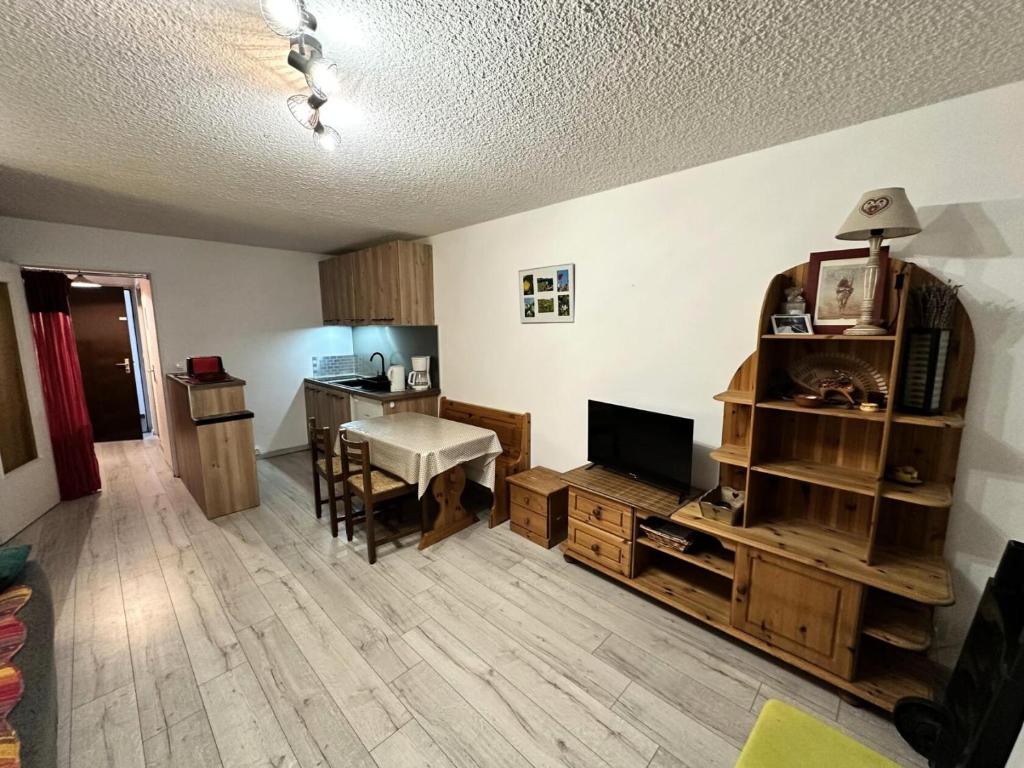 a living room with a television and a desk at Résidence Les Quatres Saisons - Studio pour 4 Personnes 004 in Corrençon-en-Vercors