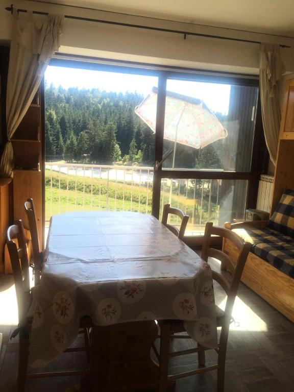 a dining room table with a view of a window at Résidence Les Fayards - Studio pour 4 Personnes 084 in Corrençon-en-Vercors