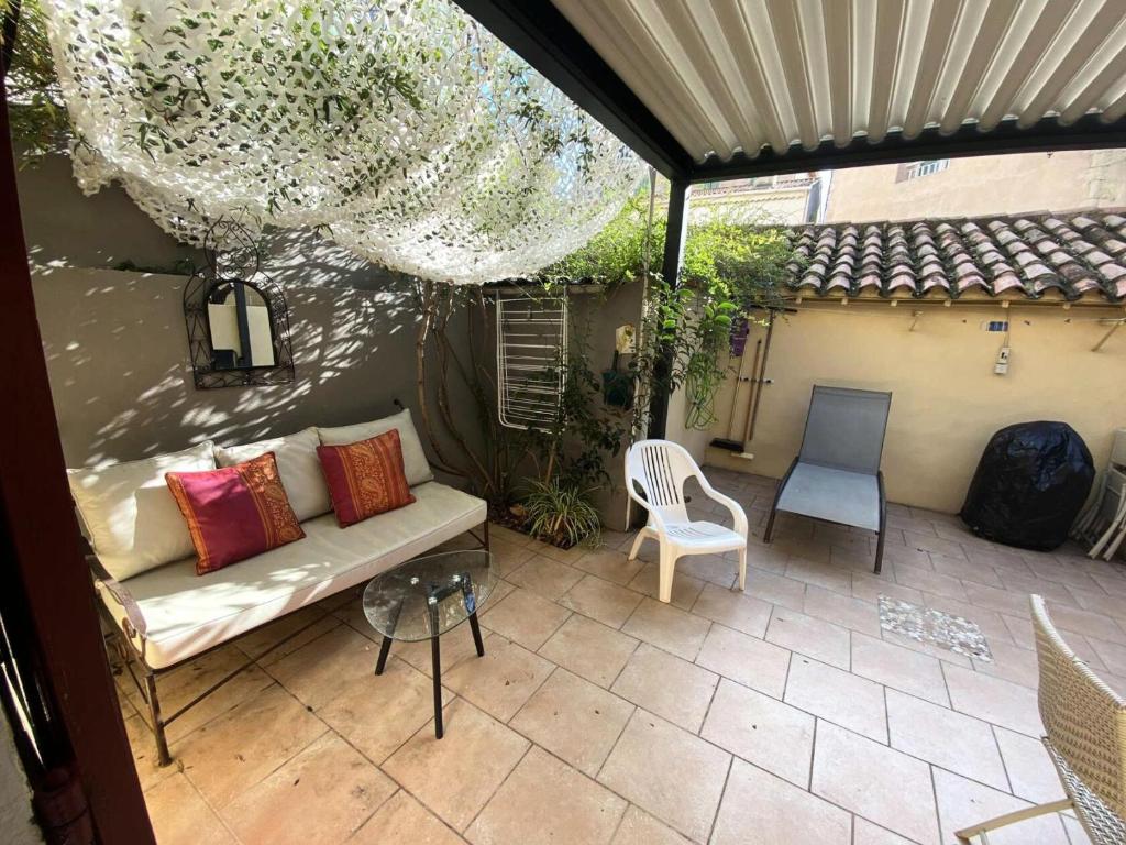 an outdoor patio with a couch and a chair at Résidence -bandol - Maisons & Villas 974 in Bandol