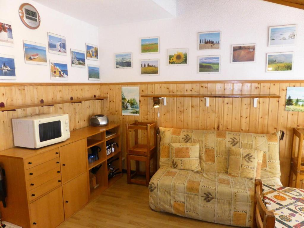 a bedroom in a cabin with a bed and a microwave at Résidence Combettes - 2 Pièces pour 4 Personnes 624 in Les Contamines-Montjoie