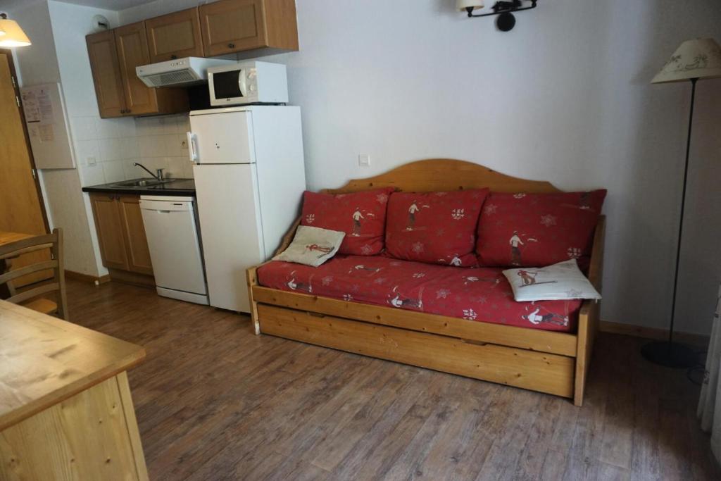 un salon avec un canapé rouge dans une cuisine dans l'établissement Résidence Terrasses De La Bergerie - 2 PIECES 4 PERSONNES MAE-2464, à Orcières