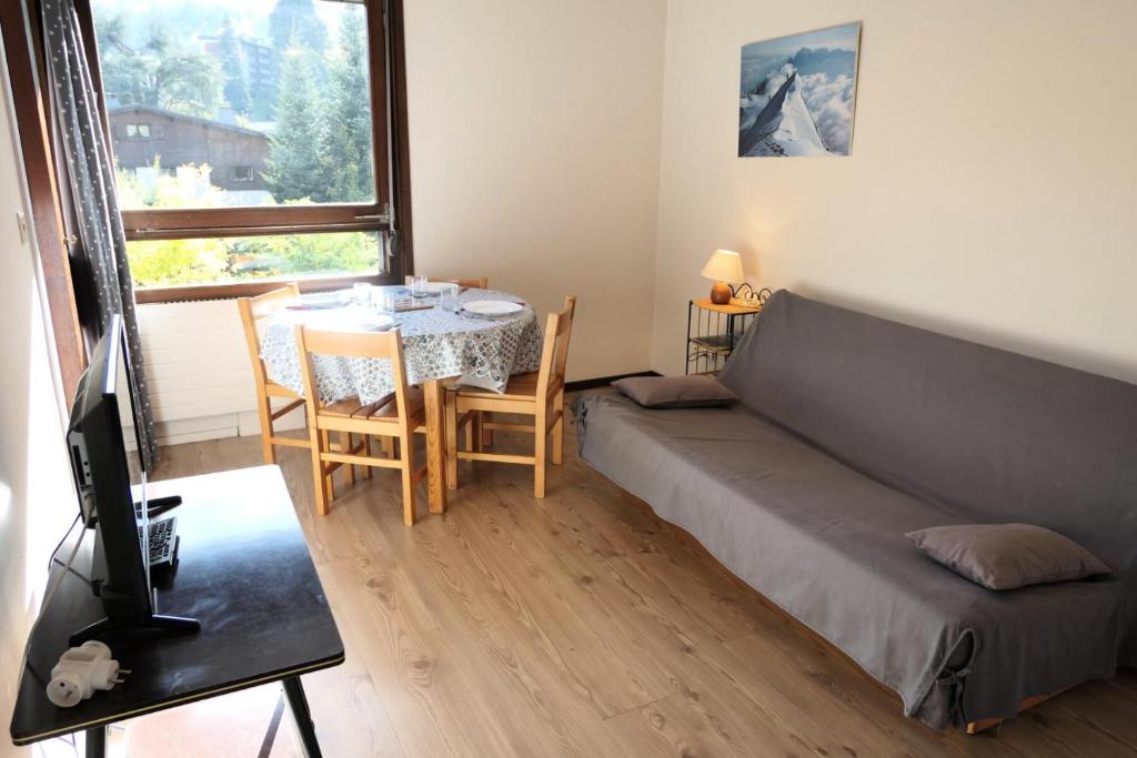 Un dormitorio con una cama y una mesa y una ventana. en Résidence Castel Des Roches C - Castel des Roches A27 MAE-4374, en Saint-Gervais-les-Bains