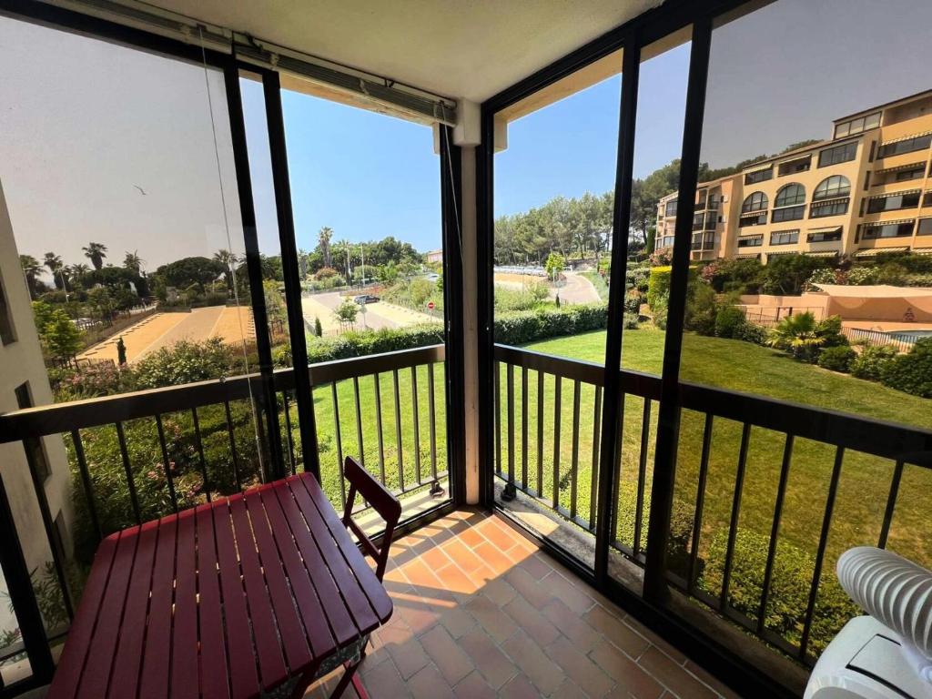 d'un balcon avec un banc et une vue sur un bâtiment. dans l'établissement Résidence Jardins D Azur B - T2 dans une résidence avec piscine dans le domaine de la Coudoulière MAE-1044, à Six-Fours-les-Plages
