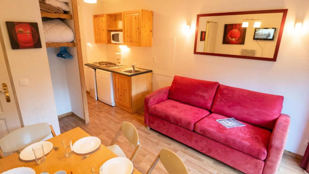 een woonkamer met een rode bank en een tafel bij Chalet De Florence - Studio pour 4 Personnes 894 in Modane