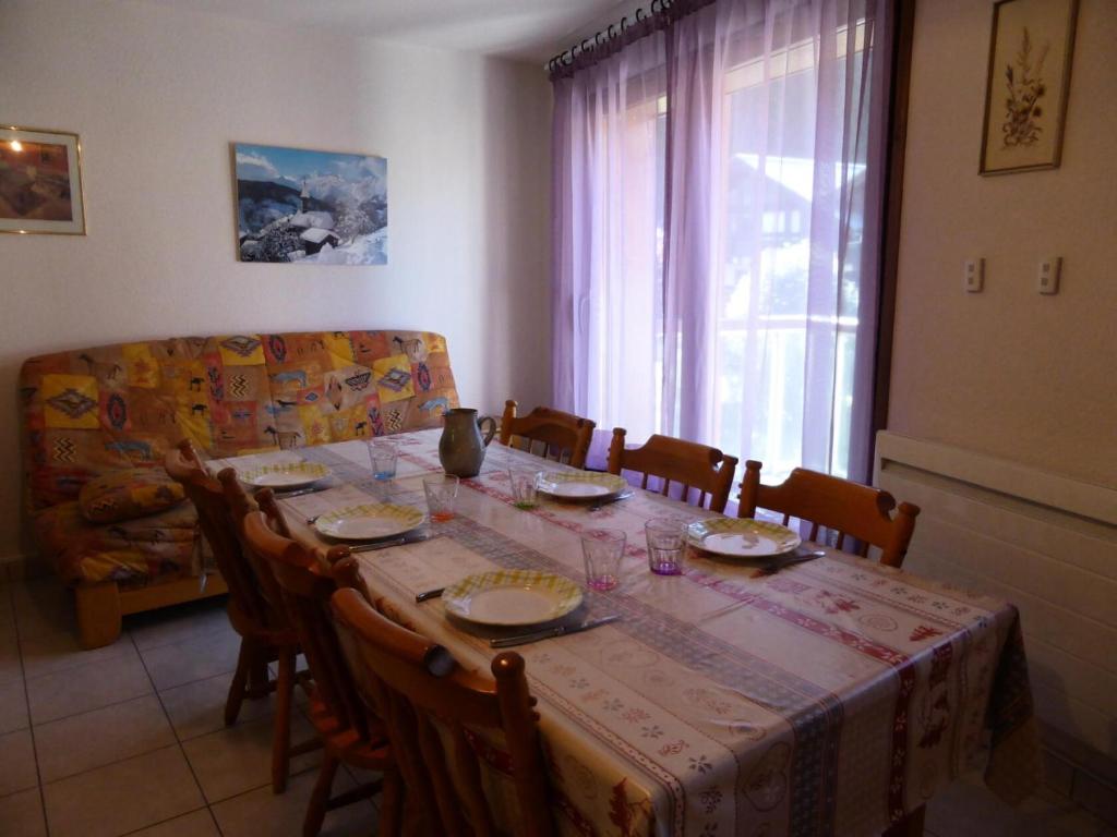 a dining room table and chairs with a table and a window at Résidence Combettes - 3 Pièces pour 5 Personnes 324 in Les Contamines-Montjoie