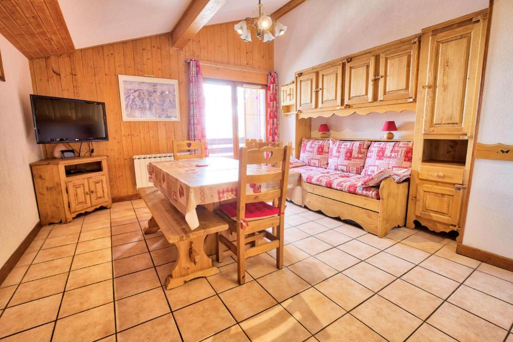 a kitchen with a table and a bed in a room at Résidence Les Oursons - 3 Pièces pour 6 Personnes 284 in Notre-Dame-de-Bellecombe