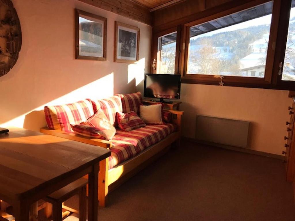 un salon avec un canapé et une télévision dans l'établissement Résidence Les Cristaux Du Bas - Cristaux 44 MAE-1984, à Combloux