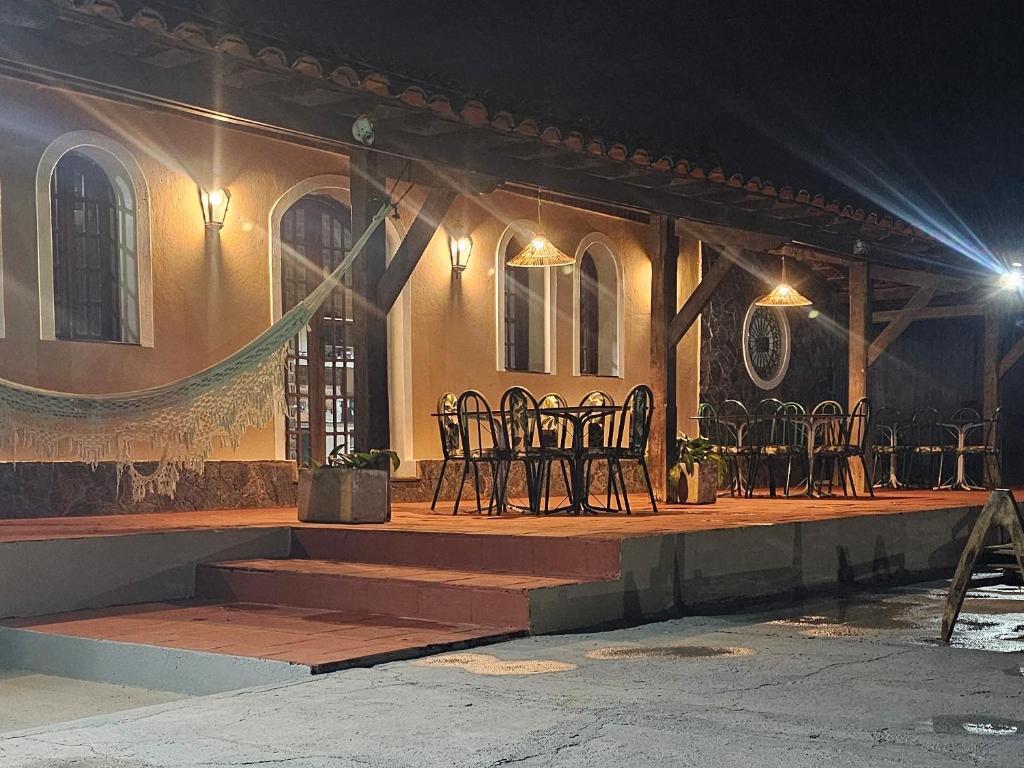 un groupe de chaises assises à l'extérieur d'un bâtiment la nuit dans l'établissement Pousada Casa Bella, à Itaberaba