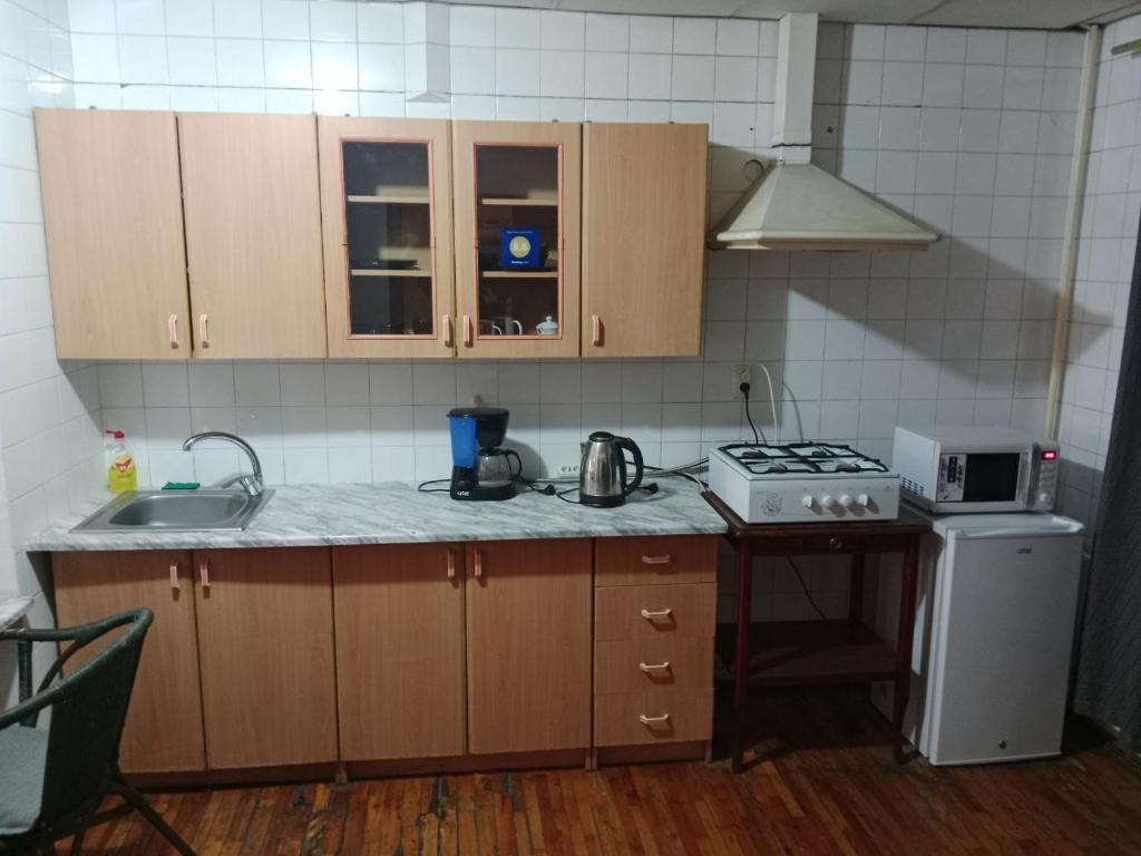 cocina con fregadero, fogones y armarios en Apartment Tsentr 5, en Tashkent