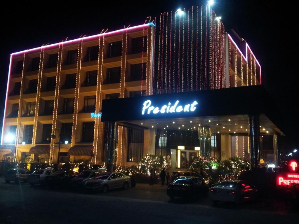 un edificio de roteland con coches aparcados delante de él por la noche en Hotel President, en Jalandhar