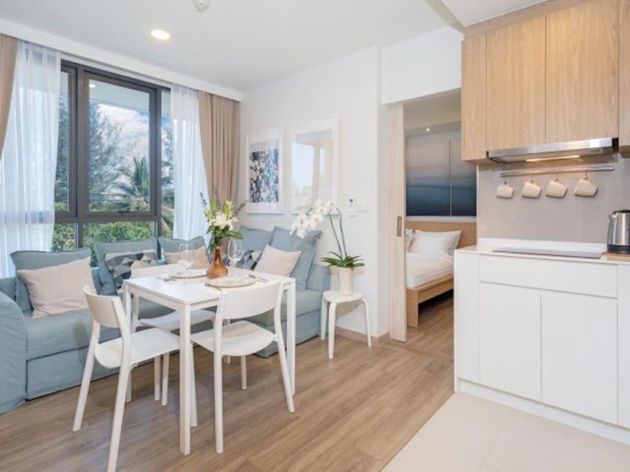 a kitchen and living room with a white table and chairs at 2 спальни Апартаменты на Бангтао 600 метров от моря in Bang Tao Beach