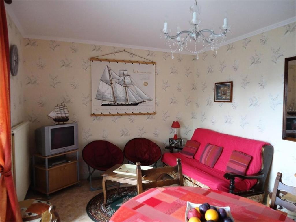 un salon avec un canapé rouge et une télévision dans l'établissement Résidence Les Goelands - Appartement T3, a proximité de toutes commodités. MAE-6634, à Pléneuf-Val-André