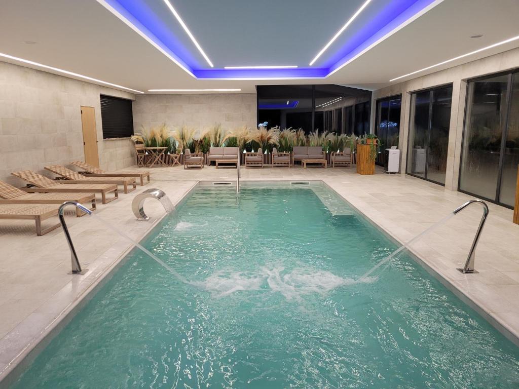 a large swimming pool in a hotel lobby with chairs at Quinta do Bento in Vieira do Minho