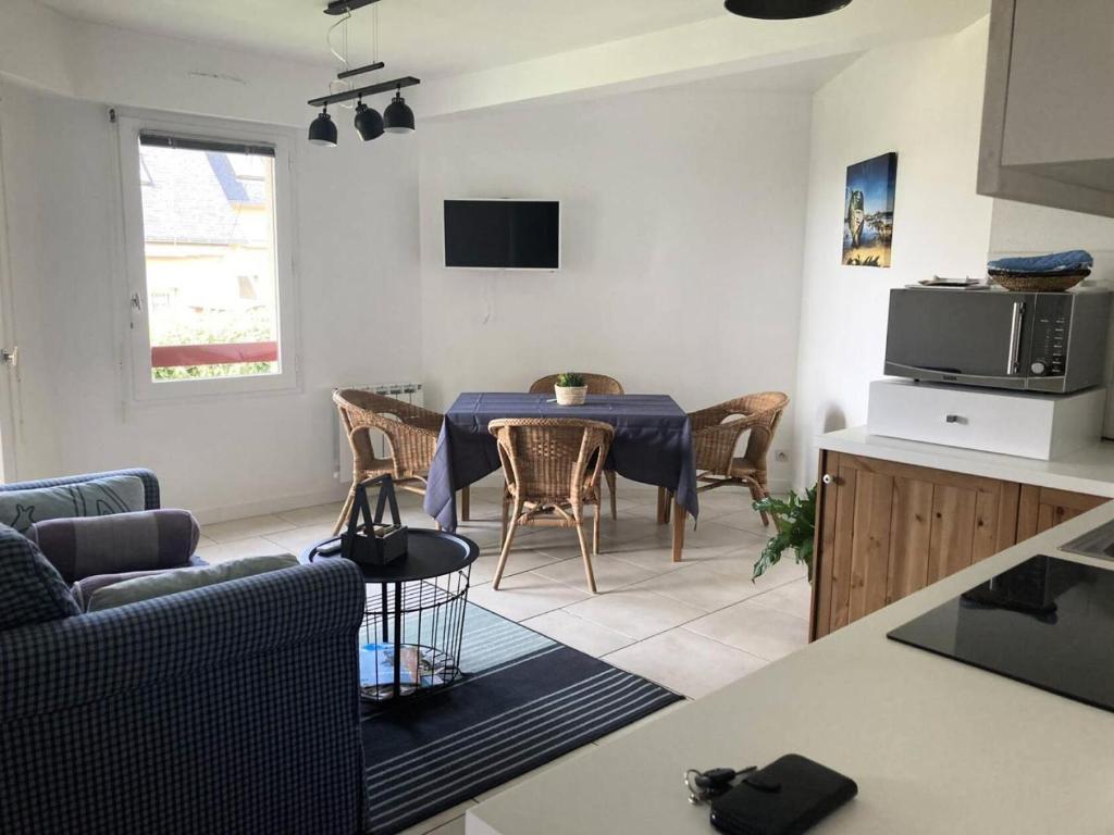 een keuken en een woonkamer met een tafel en stoelen bij Résidence Genets - 2 Pièces pour 2 Personnes 734 in Pléneuf-Val-André