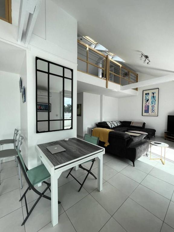 un salon avec une table et un canapé dans l'établissement Résidence Le Rocher - Appartement duplex avec vue sur les toits du val andré MAE-5384, à Pléneuf-Val-André