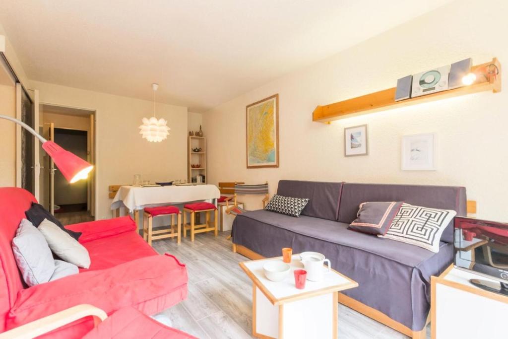 een woonkamer met een bank en een tafel bij Résidence Orion - Studio pour 5 Personnes 584 in Le Corbier