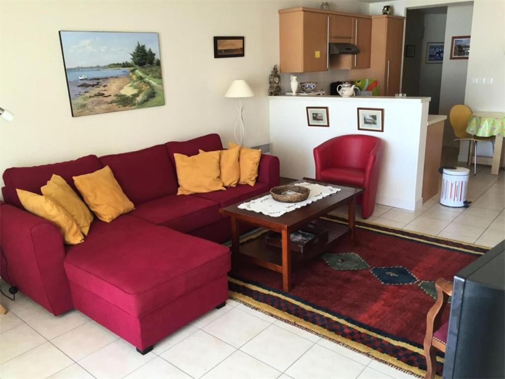un salon avec un canapé rouge et une table dans l'établissement Résidence Les Bains - Charmant T3 à deux pas de la plage du Val André. MAE-6644, à Pléneuf-Val-André