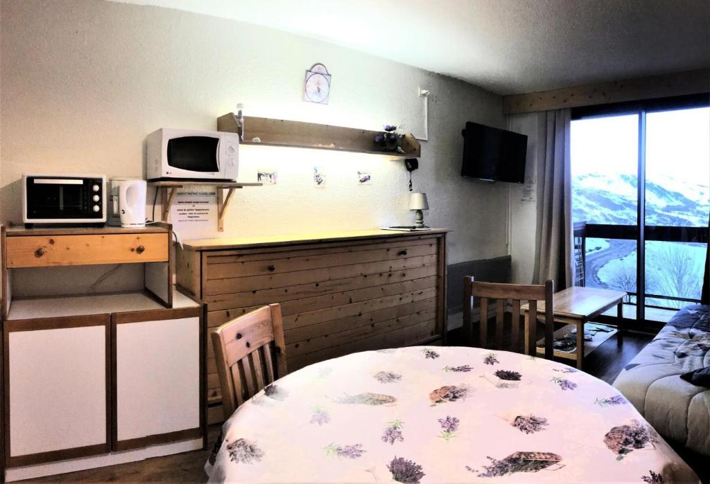 une petite cuisine avec une table et un micro-ondes dans l'établissement Résidence Lunik - APPARTEMENT DEUX PIECES 5 PERSONNES MAE-9404, au Corbier
