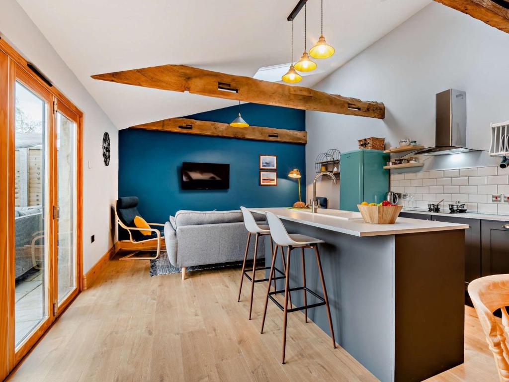 cocina con paredes azules y encimera con taburetes en 2 Bed in Cheddar 91358, en Loxton