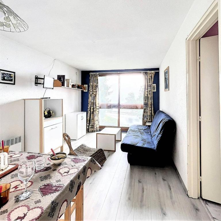 una sala de estar con un sofá y una mesa en Résidence Phenix - STUDIO CABINE 4/5 PERSONNES MAE-9734, en Le Corbier