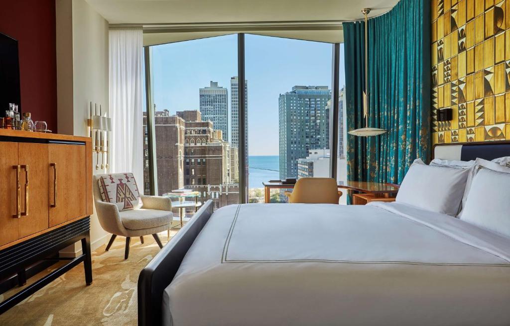 a hotel room with a bed and a large window at Viceroy Chicago in Chicago