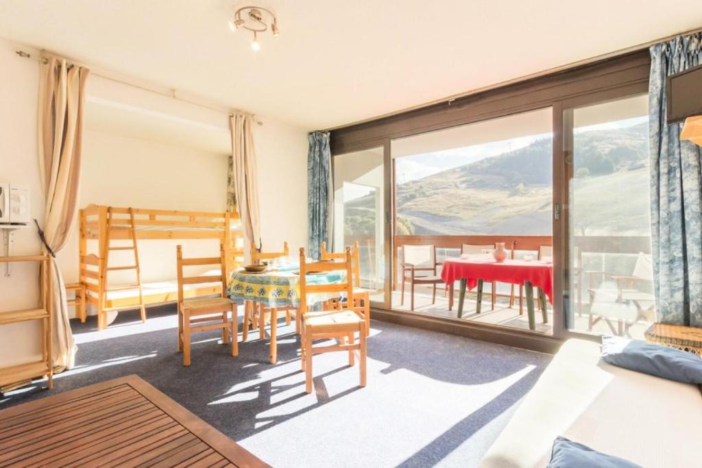 un salon avec une table et des chaises et un balcon dans l'établissement Résidence Baikonour - STUDIO 4 PERSONNES BAIKONOUR MAE-9744, au Corbier