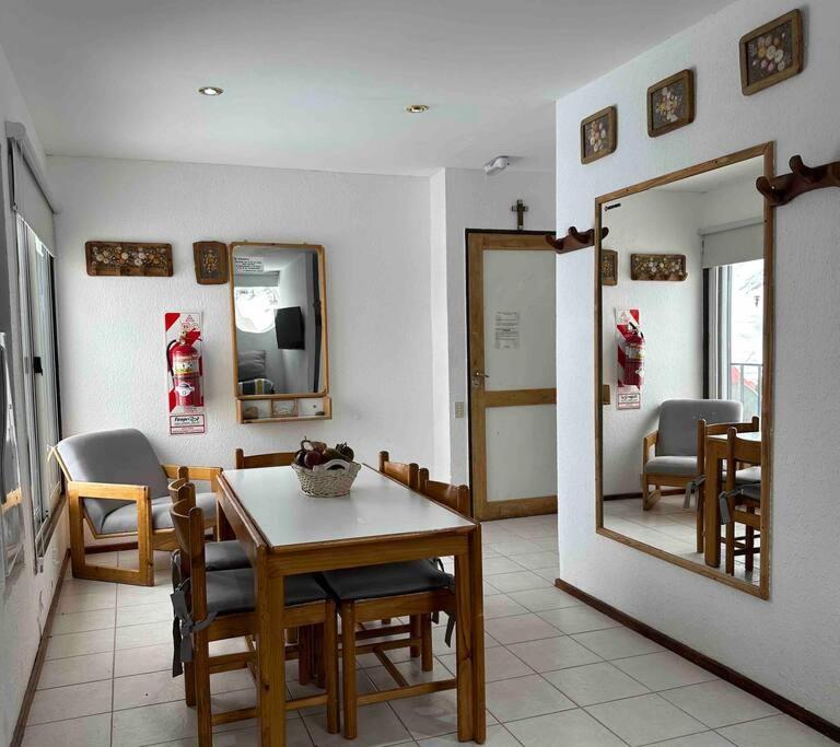 a dining room with a table and a mirror at Departamento en el Valle Las leñas in Las Lenas