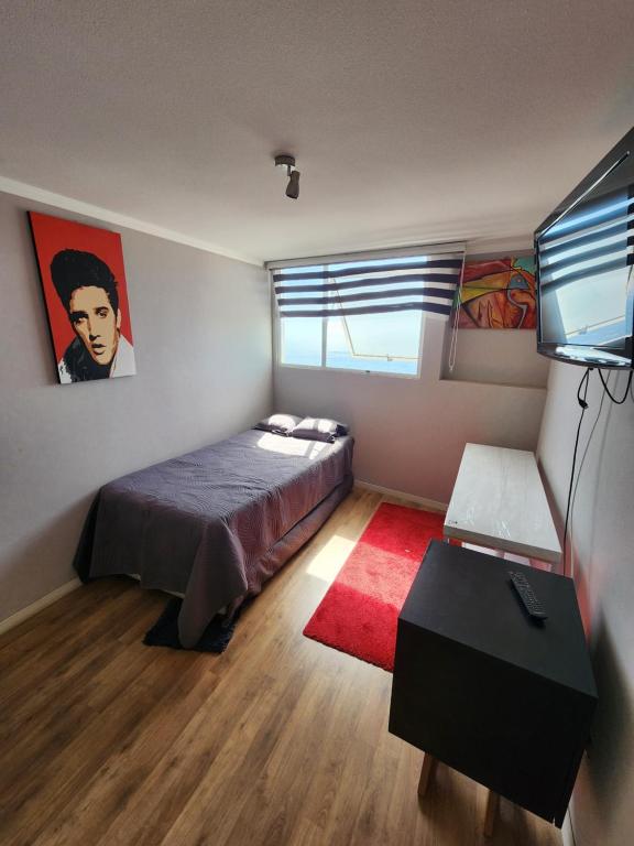 a bedroom with a bed and a red rug at Playa Huayquique, primera linea in Iquique
