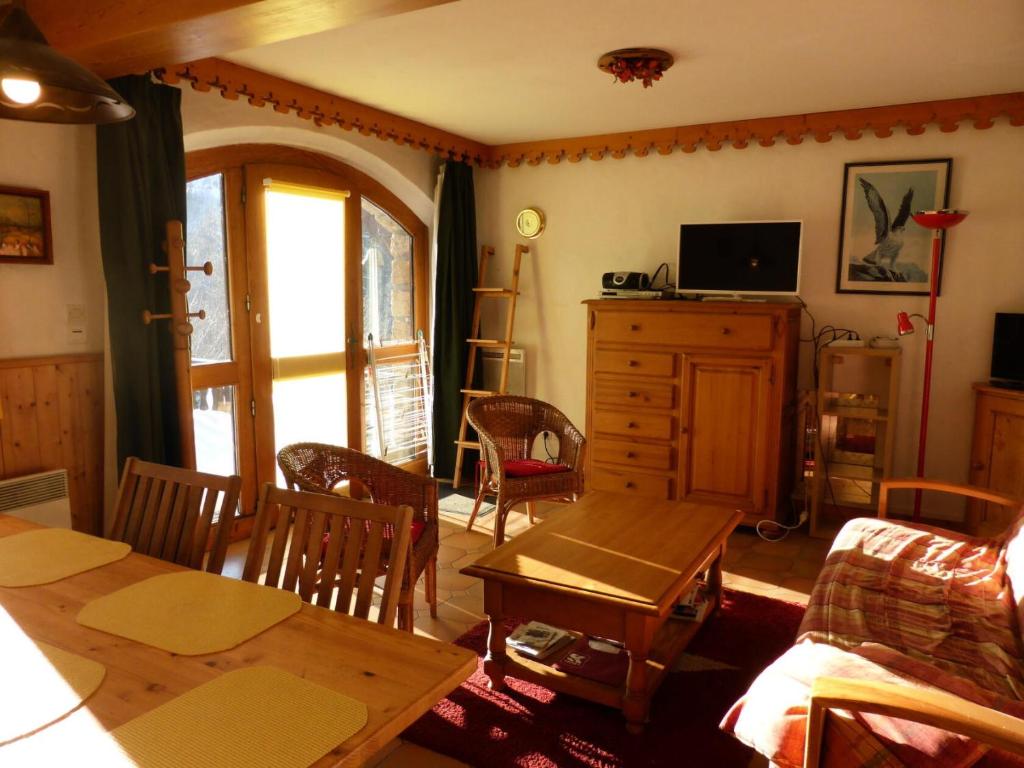 un salon avec une table et une télévision dans l'établissement Résidence La Cordee - Cordée 2 MAE-0224, aux Contamines-Montjoie