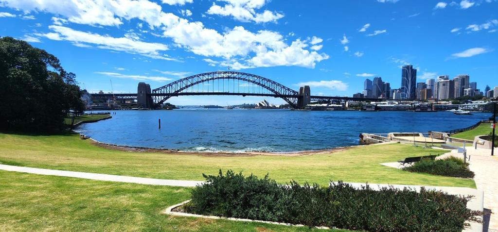 a bridge over a river with a city in the background at Harbourside Escape: Sunlit Outdoor Terrace & Views in Sydney