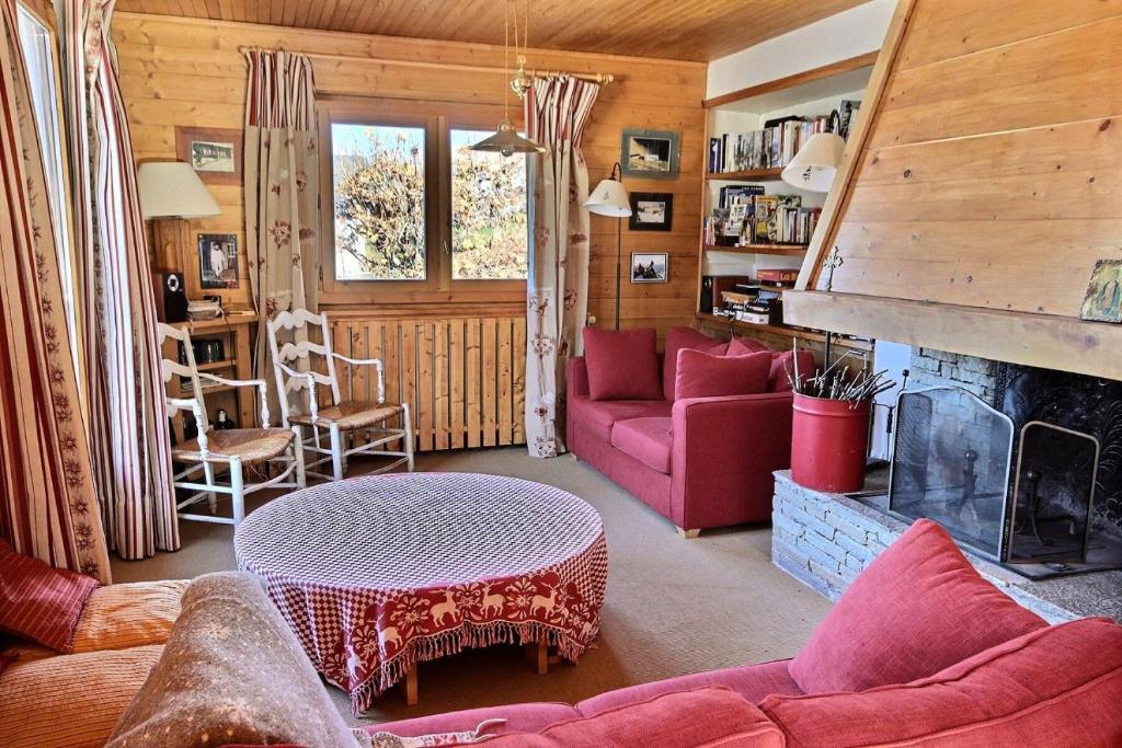 uma sala de estar com um sofá vermelho e uma lareira em Chalet L'isard - Chalets pour 10 Personnes 534 em Peisey-Nancroix