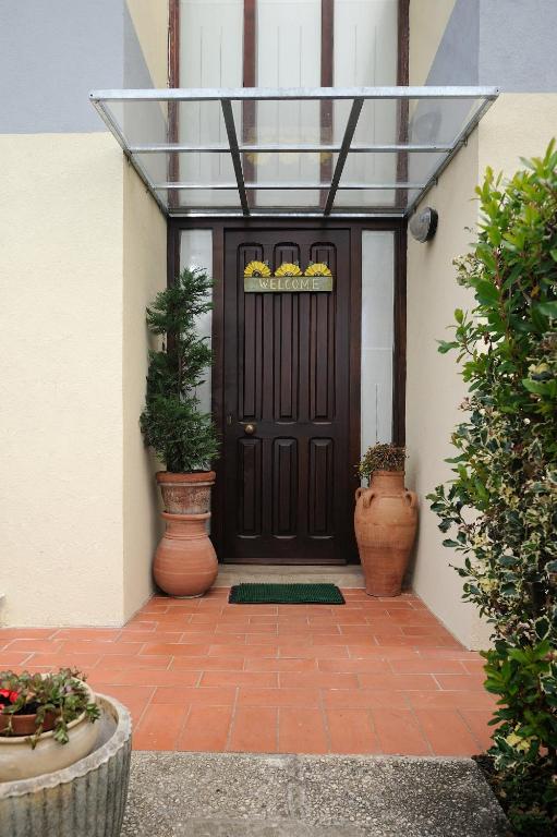 une porte d'entrée d'une maison avec des plantes en pot dans l'établissement Villa La Certosa, à Pise