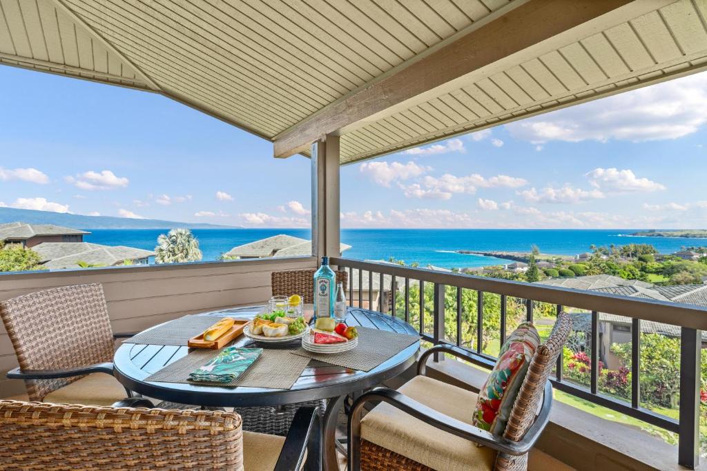a table and chairs on a balcony with a view of the ocean at Kapalua Ridge Villas 1423 in Kahana