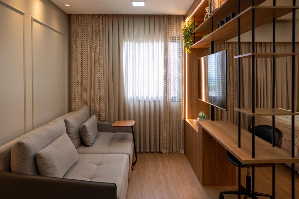 uma sala de estar com um sofá e uma mesa em Studio Cosmopolita - Novo - possui automação em Nova Santa Medianeira