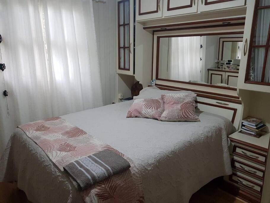 - une chambre avec un lit et un grand miroir dans l'établissement Casa Mimosa, à Gramado