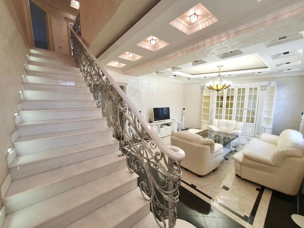 eine Wendeltreppe in einem Wohnzimmer mit einem Sofa und Stühlen in der Unterkunft Роскошная двухуровневая квартира Luxurious duplex apartment in Yerevan