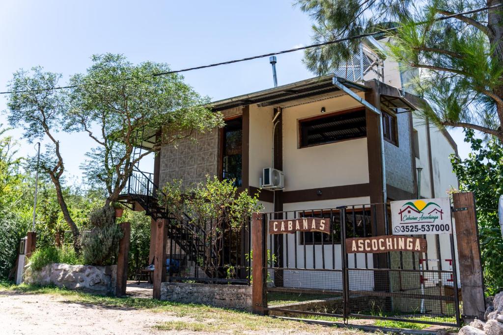 una casa con una puerta delante de ella en Cabañas Ascochinga en Ascochinga