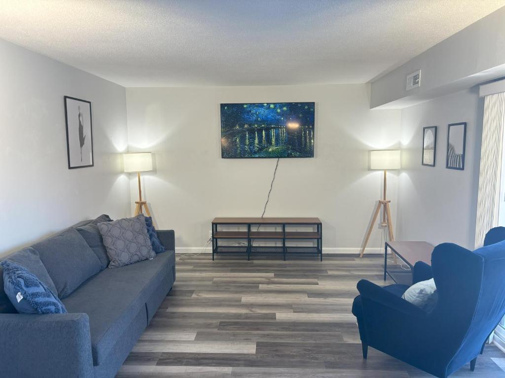 a living room with a blue couch and two chairs at Gorgeous Remodeled Classy Family Apartment in Granite City