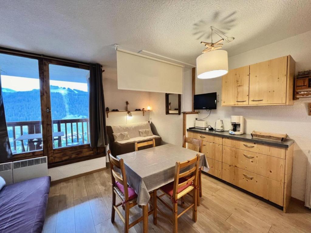 a kitchen and dining room with a table with a view at Résidence Le Zenith - Studio pour 4 Personnes 384 in Notre-Dame-de-Bellecombe