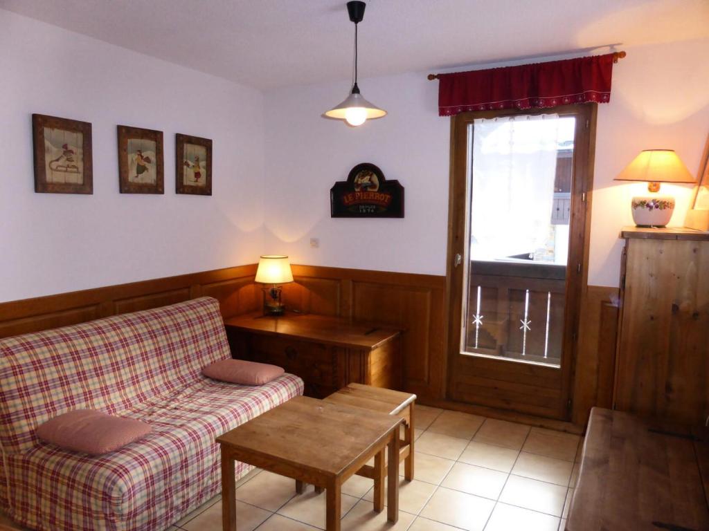 un salon avec un canapé, une table et une fenêtre dans l'établissement Résidence Les Cimes D'or A - Cîmes d'Or A28 MAE-6344, aux Contamines-Montjoie