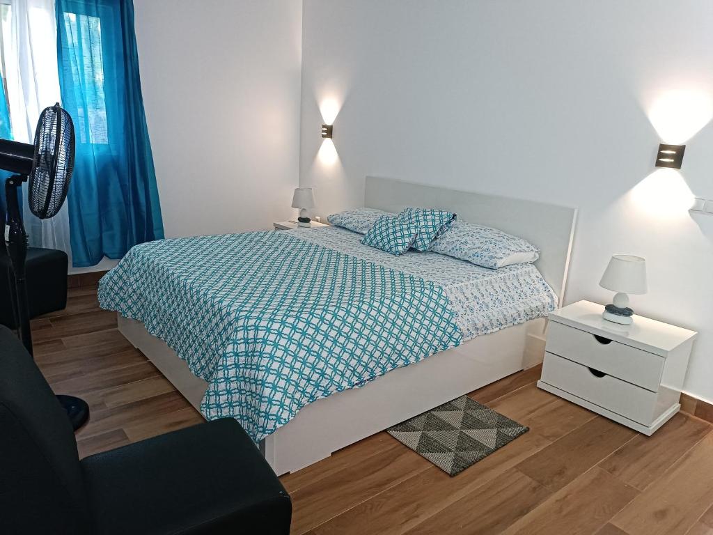 Schlafzimmer mit einem Bett mit einer blauen und weißen Bettdecke in der Unterkunft Espaço-Vila Verde 