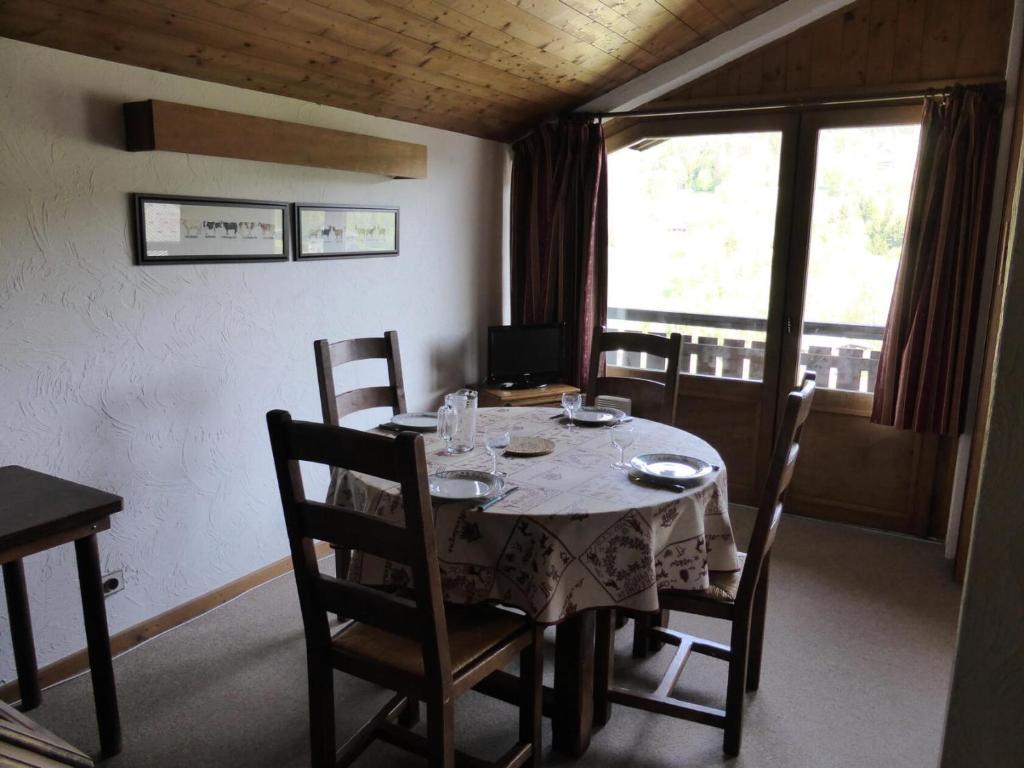 uma sala de jantar com uma mesa e cadeiras e uma janela em Résidence Princesse En Etraz Narcisse - 3 Pièces pour 6 Personnes 294 em Combloux