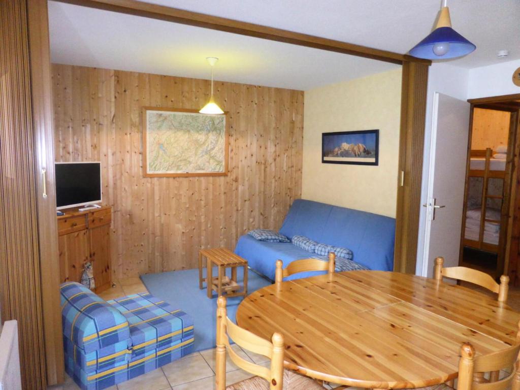 a living room with a table and a blue couch at Résidence Les Cimes D'or A - 2 Pièces pour 4 Personnes 704 in Les Contamines-Montjoie