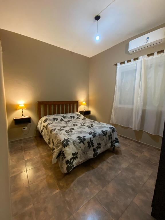 Un dormitorio con una cama y dos lámparas sobre mesas. en kairos, en La Falda