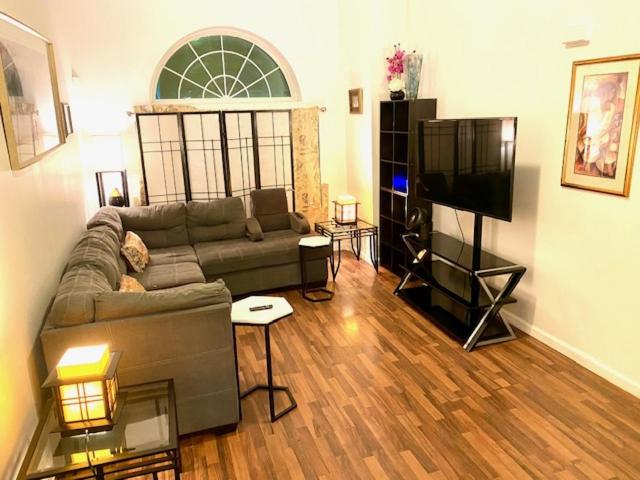 a living room with a couch and a flat screen tv at HUGE 2 bedroom Apt FREE street parking (king bed) in Baltimore