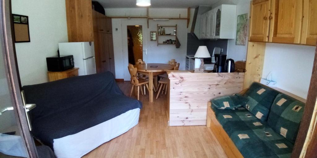 a room with a bed and a kitchen with a table at Résidence Les Quatres Saisons - Studio pour 4 Personnes 054 in Corrençon-en-Vercors