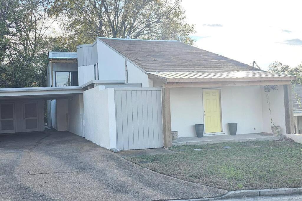 una casa bianca con un garage con una porta gialla di Fully Furnished Vicksburg Home Sleeps 10 a Vicksburg