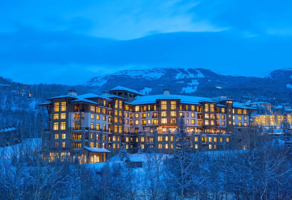 un gran edificio con sus luces encendidas por la noche en Viceroy Snowmass en Snowmass Village