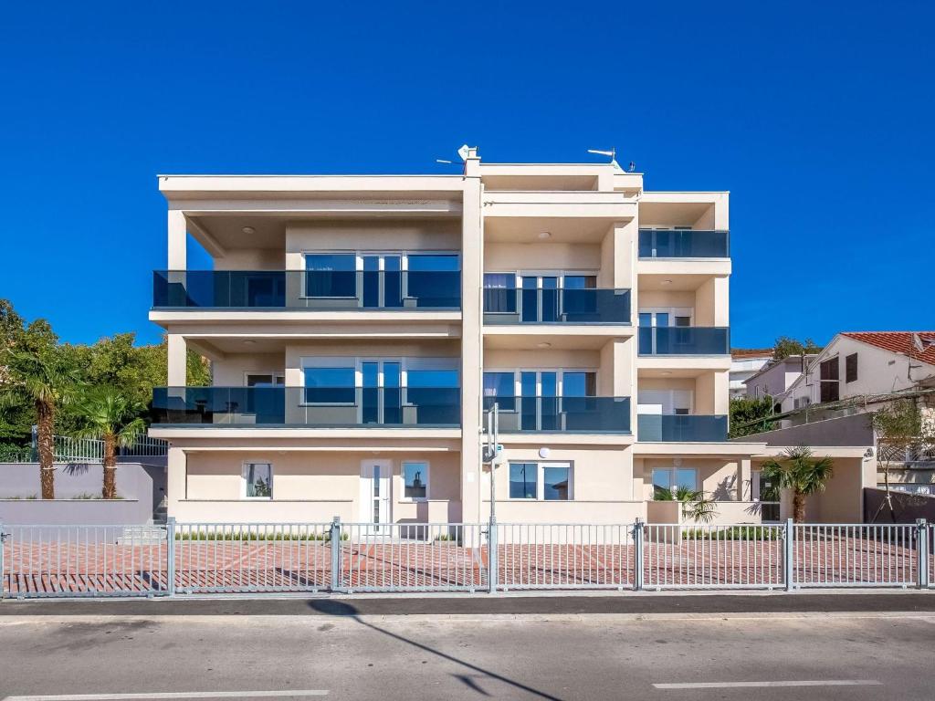 a white building with blue balconies on a street at Gorgeous homes with swimming pool jacuzzi and a magnificent sea view in Dramalj